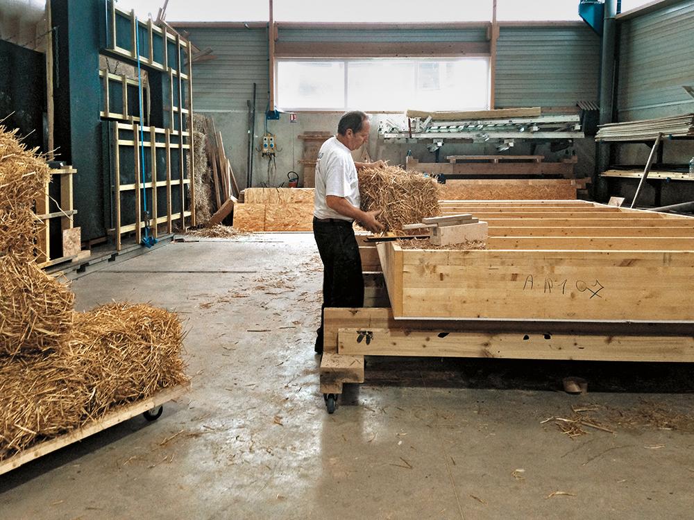 In einer lokalen Werkstatt wurden einfache Holzrahmen mit gepressten Strohballen befüllt. Holz und Stroh stammen von Wäldern und Feldern aus der Region.