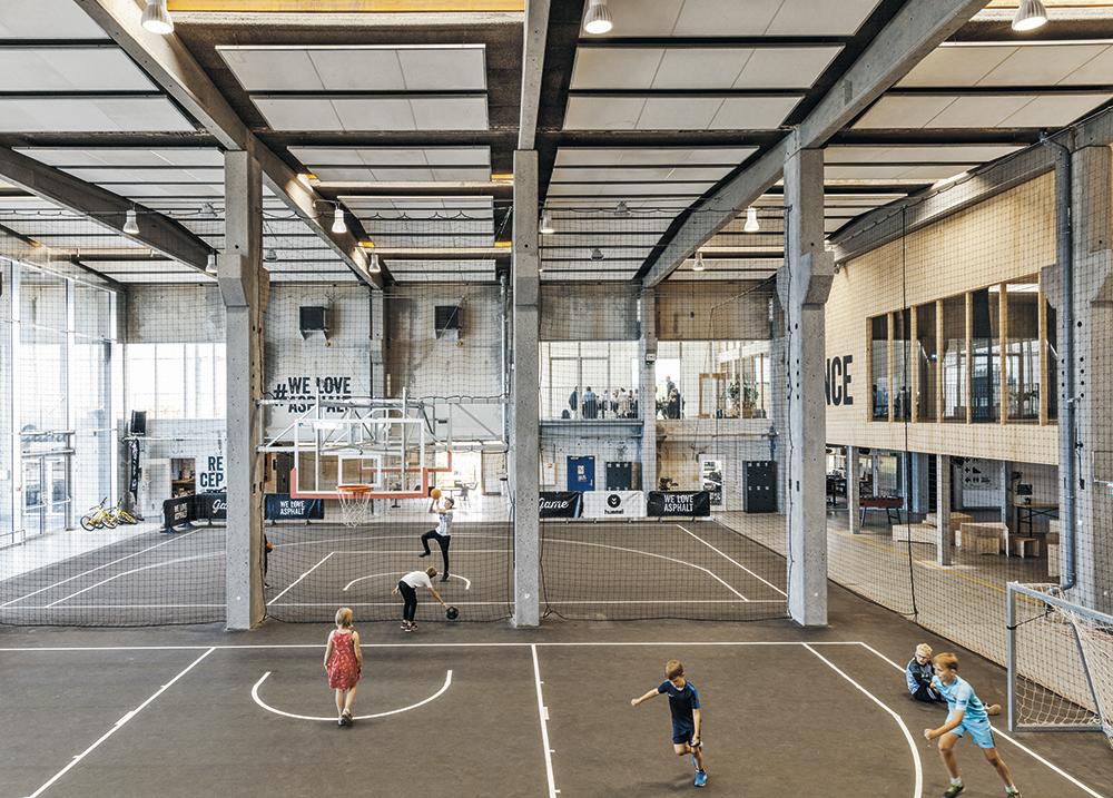 Von den umliegenden Werkstätten und Aufenthaltsbereichen hat man einen freien Blick auf das Sportgeschehen und die beeindruckenden Proportionen der zentralen Halle.