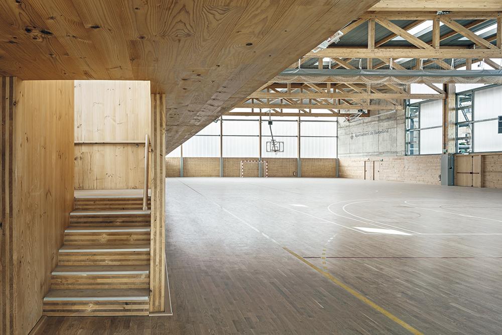 Die Sporthalle kommt dank Polycarbonatplatten und Oberlichtern fast gänzlich ohne elektrisches Licht aus. Als Sonnenschutz dient die vertikale Fassadenbegrünung.