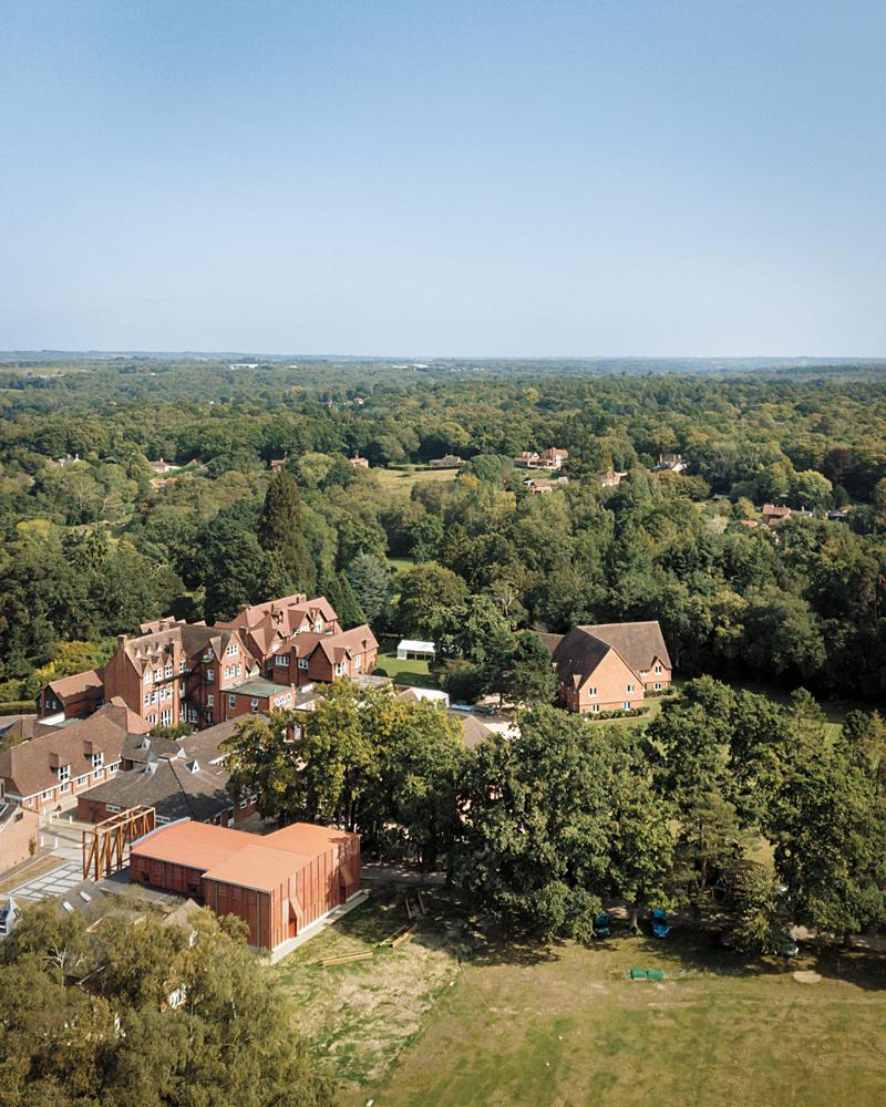 Der Theaterneubau steht an der Zufahrt zum Gelände der Horris Hill School etwas südlich von Newbury. Mit seiner ziegelroten Gebäudehülle fügt er sich harmonisch zwischen die Bestandsgebäude ein.