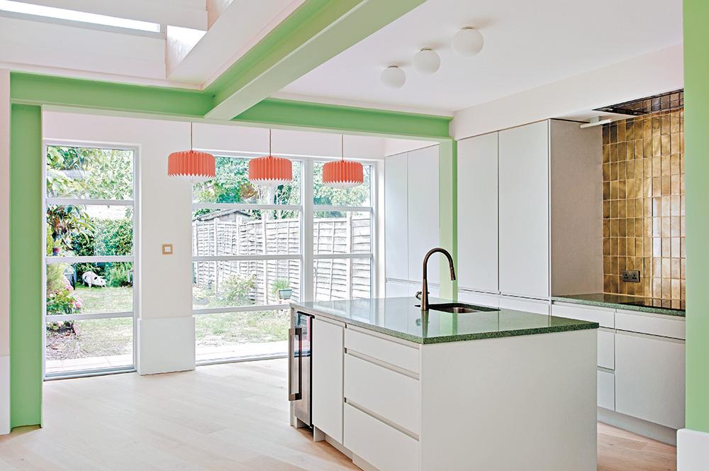 The structure and shape of the roof divide the extension into two parts: the bright work area with its striking northlight roof and the flatroofed kitchen with the freestanding kitchen block.