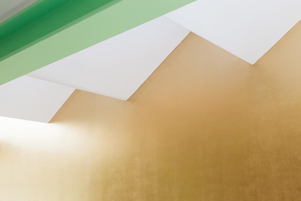 Dachform und -tragwerk gliedern den Anbau in zwei Teile: der hell erleuchtete Arbeitsbereich mit seinem markanten Sheddach und die flach gedeckte Küche mit frei stehendem Küchenblock.