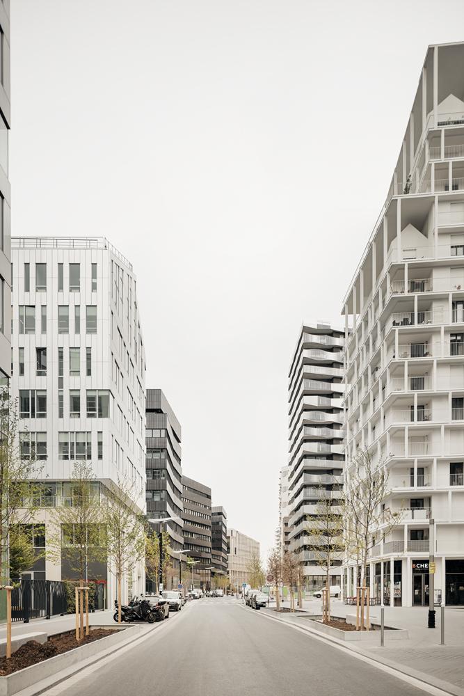 Die tiefe Straßenschlucht zwischen Büros und Wohntürmen wird durch Läden, Gastronomie, Kindertagesstätten und eine neue Metrostation zum urbanen Stadtraum.