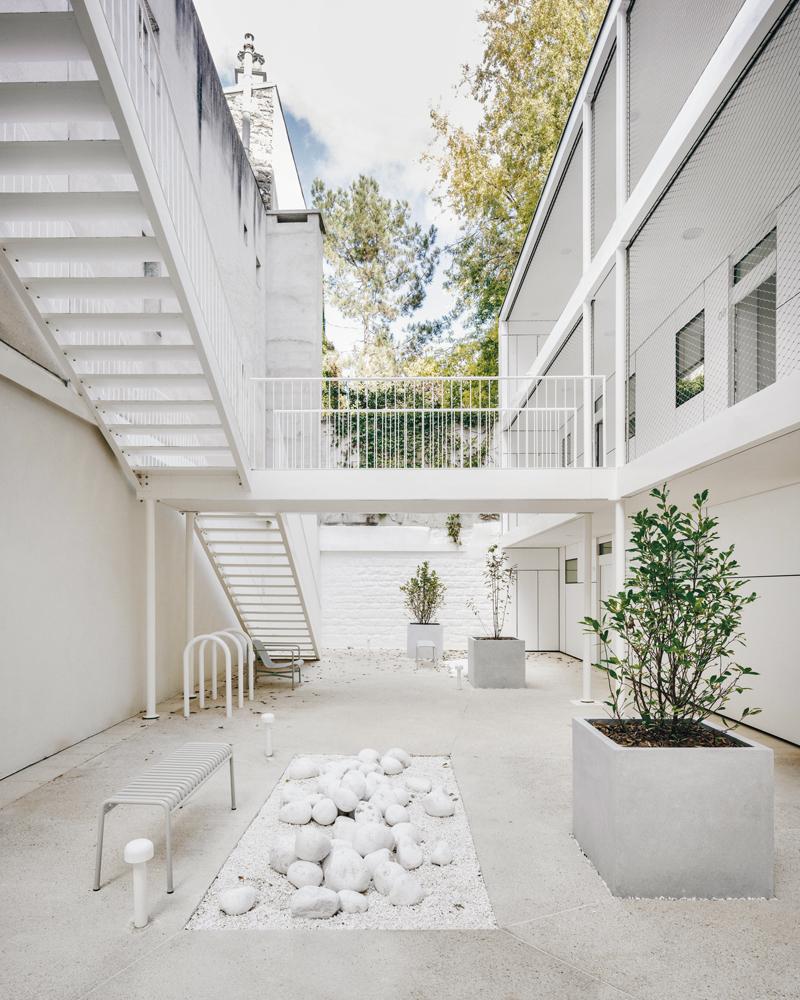 The interior courtyard provides access to the new residential building. It is all white and can only be reached through a passageway