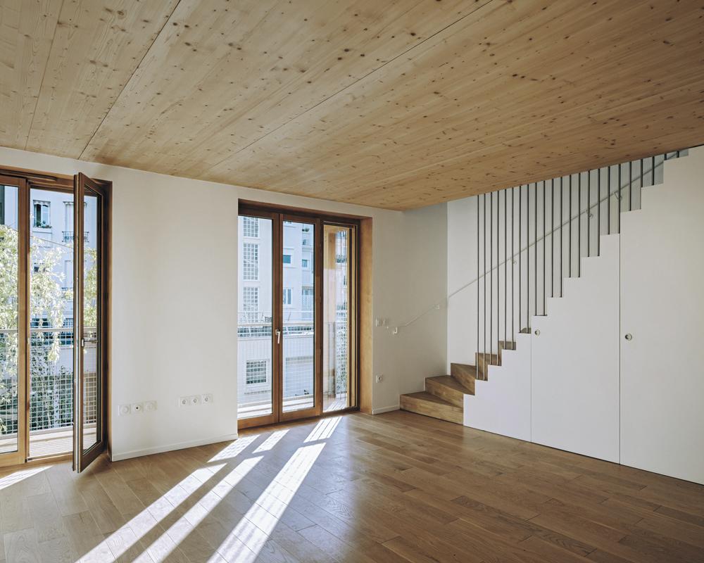 Mit raumhohen Fenstertüren orientieren sich die Wohnräume zum Garten hin. In den vier Maisonettewohnungen führt eine Treppe nach oben in die Schlafzimmer.