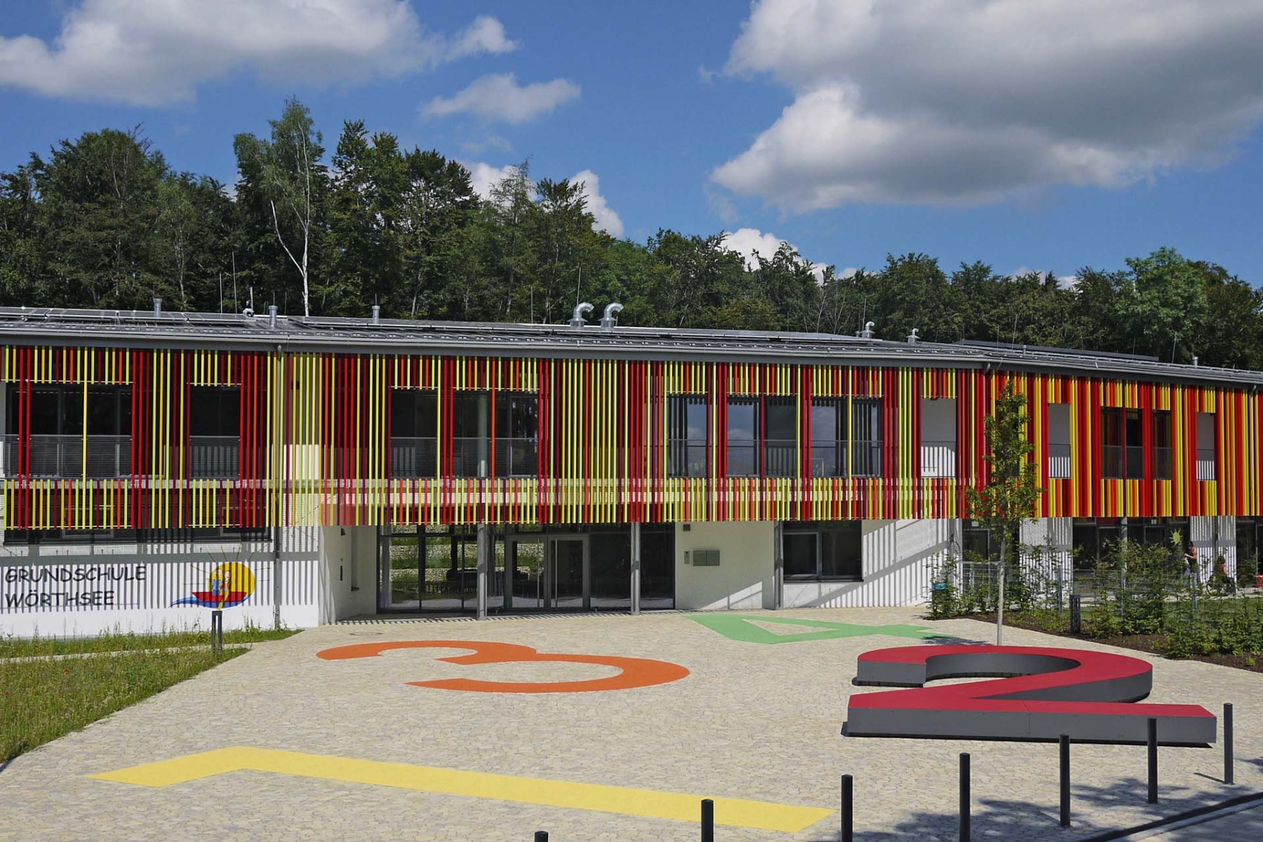 Farbige Schule mit lebendigem Pflasterbelag