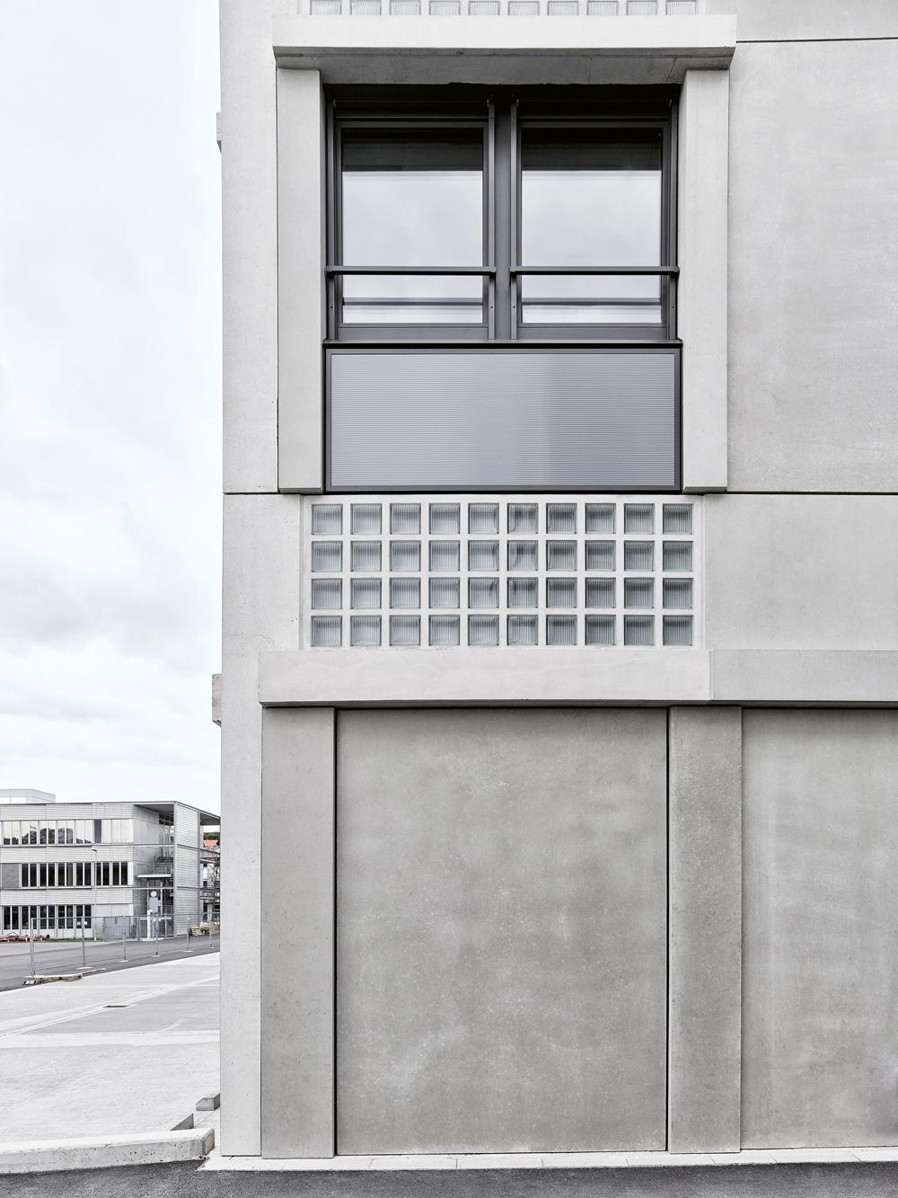 Die einzelnen Fassadenabschnitte sind entsprechend ihrer Ausrichtung unterschiedlich gestaltet. Vorgefertigte Füllungen aus Glasbausteinen in den Fensterstürzen und Photovoltaikpaneele in den Brüstungen verweisen auf den industriellen Charakter der Umgebung.