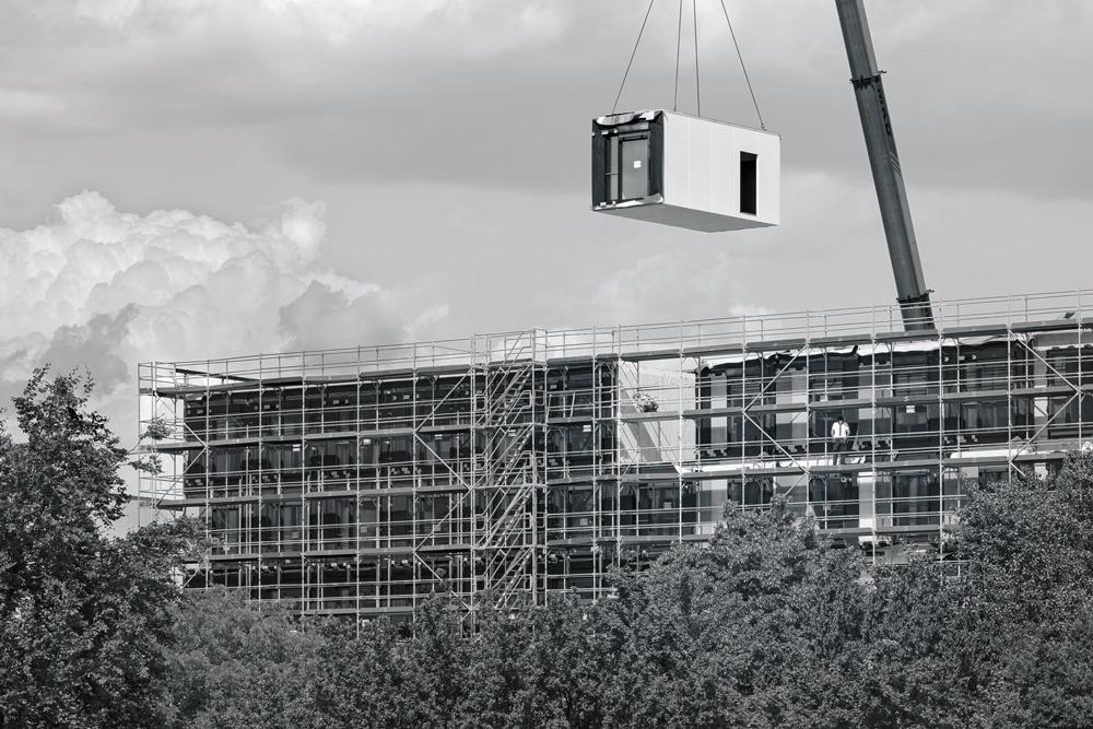 Rund 460 Raummodule wurden in einer eigens zu diesem Zweck angemieteten Industriehalle vorgefertigt und mithilfe von Lastkränen am Bauplatz aufeinandergestapelt.