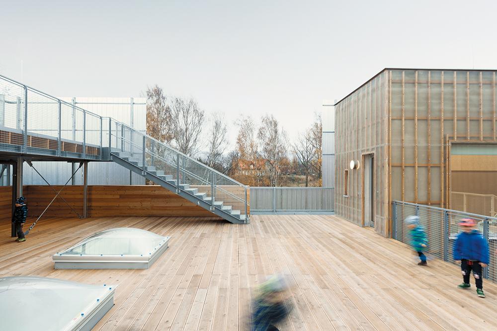 Der zweiteilige Neubau ergänzt die alten Werkstätten im verschachtelten Hinterhof. Durch die Abstufung des Baukörpers an der Straße entstand eine großzügige Terrasse.