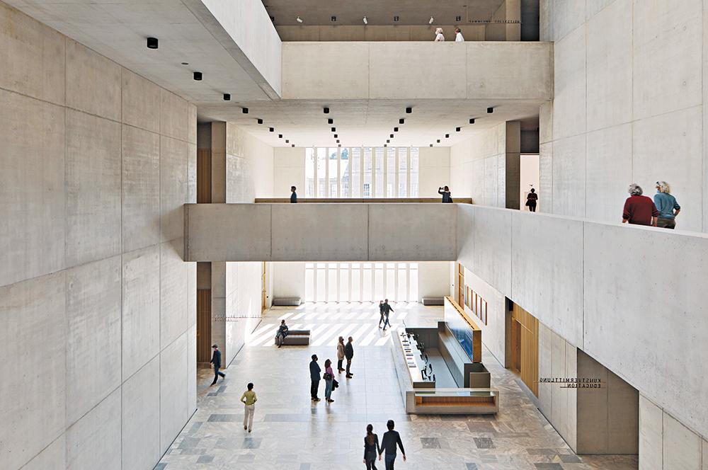 Die zentrale Eingangshalle dient als Foyer und öffentliche Passage zwischen Heimplatz und Kunstgarten. Sichtbeton, Marmor und Messing prägen die Innenräume.