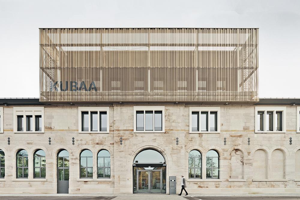 Canted sheet steel envelops the upper two floors of the cultural complex. They conceal a music school, a ballet studio and building services above them.