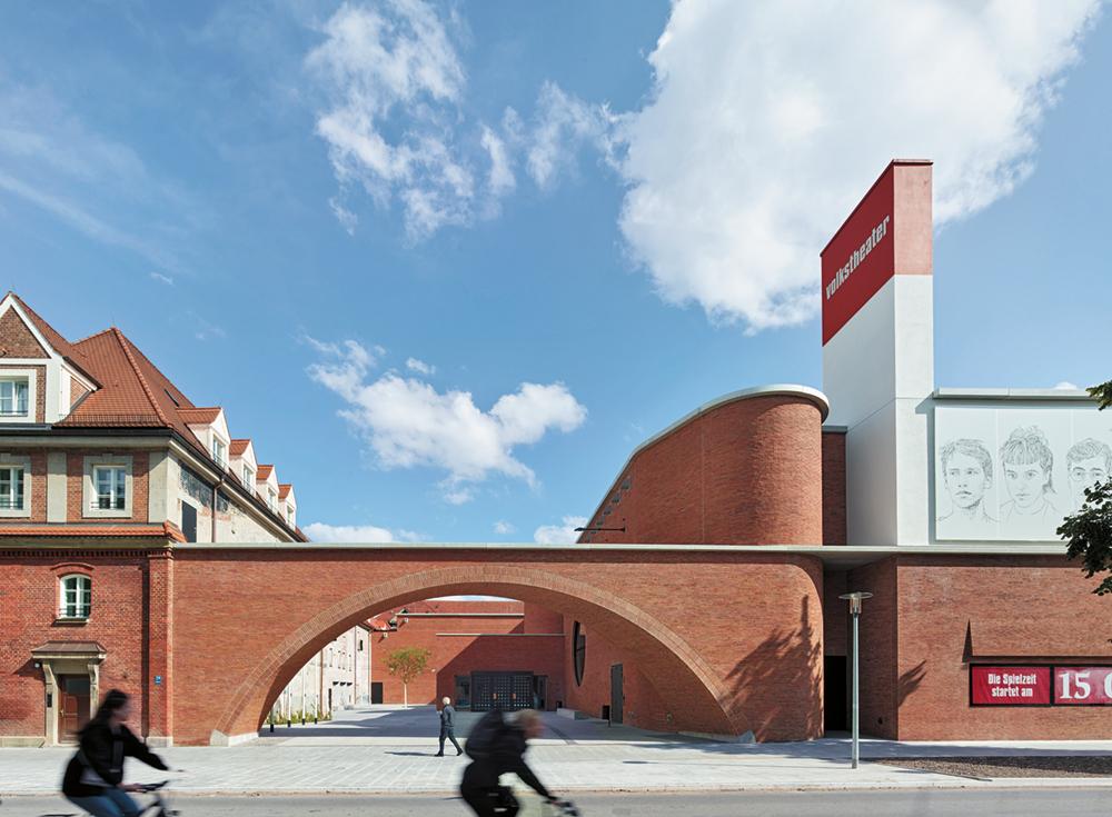 Der große Torbogen markiert den Eingang zum neuen Volkstheater. Dahinter liegen das Foyer im Freien und ein Biergarten.