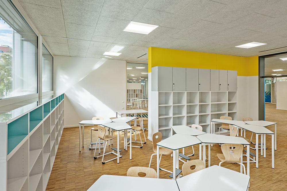 Je vier bis fünf Klassenräume setzen sich zu einem Cluster zusammen. Spiegel auf der Regaloberseite lenken das direkte Sonnenlicht tiefer in die Räume.