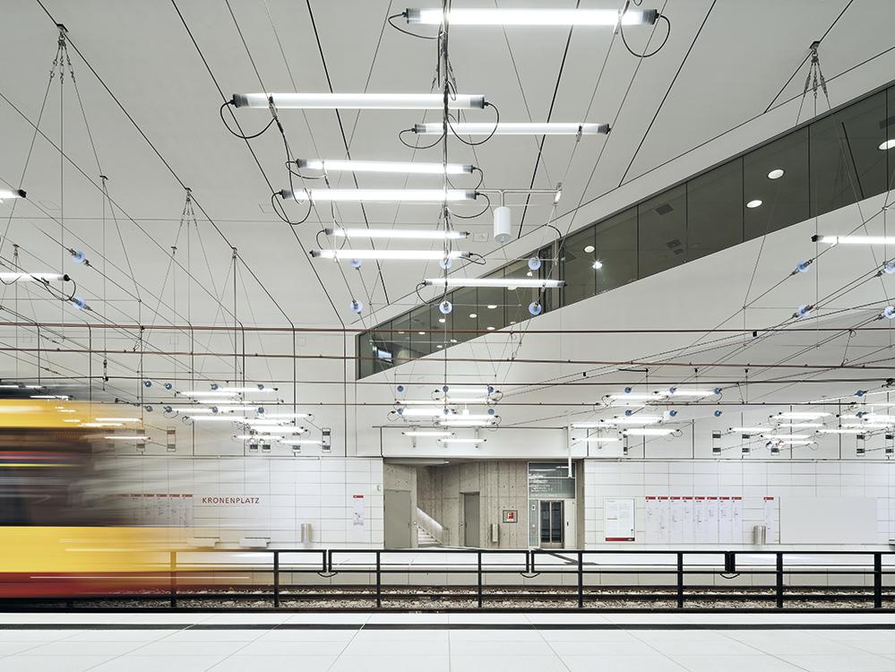 Im Gegensatz zu U-Bahnhöfen fahren im Stadtbahntunnel von Karlsruhe Straßenbahnen. Die Oberleitungen inspirierten das Team von Ingo Maurer zu seinem Lichtkonzept, das die Elektrizität feiert. Die ruhigen Räume von Allmann Sattler Wappner verstärken dessen Wirkung.