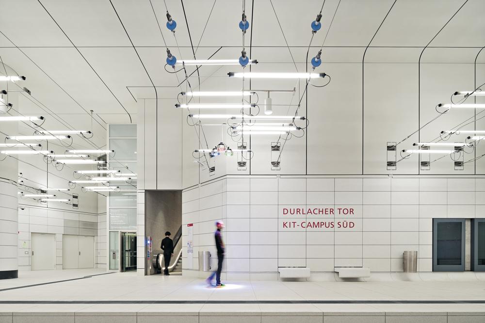 Die untere Hälfte der Raumschale mit integrierten Sitzbänken ist aus Betonwerkstein, der von Putzfahrzeugen gereinigt werden kann. Darüber bilden Trockenbauplatten Wand und Decke.