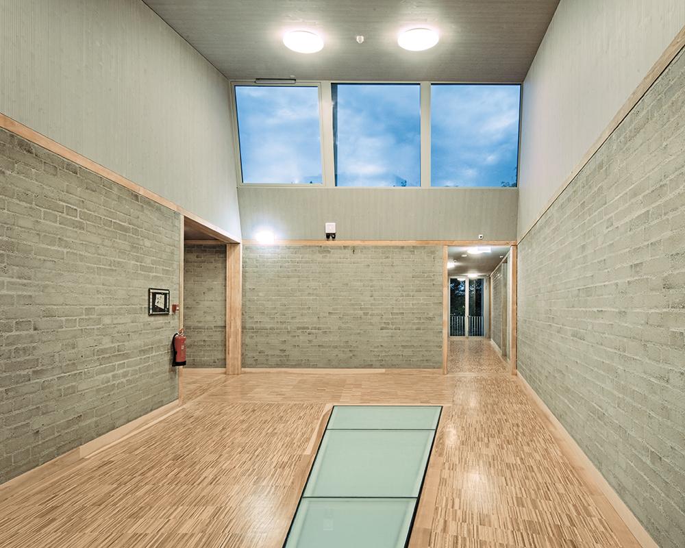 The large skylight and a glazed ceiling surface above the ground floor allow daylight to enter the building and reach the foyer.