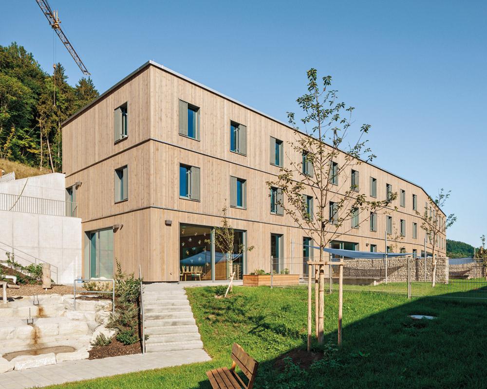 Ein Kindergarten nimmt den größten Teil des Erdgeschosses ein. Auf die beiden Obergeschosse verteilen sich 30 Gästezimmer. Aus jedem Geschoss führen Ausgänge direkt ins Freie.