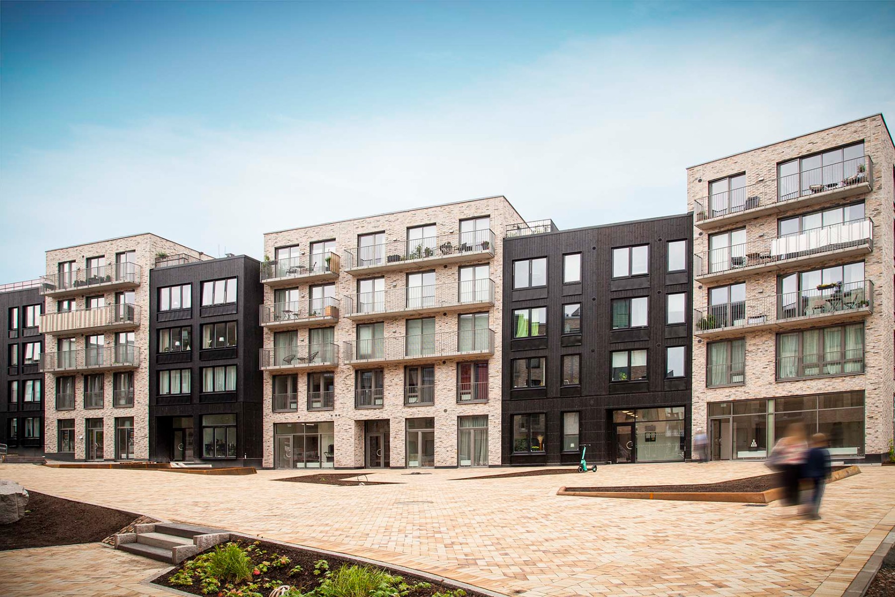 Gebäudehüllen aus Verblendziegeln und Holz für Wohnquartier