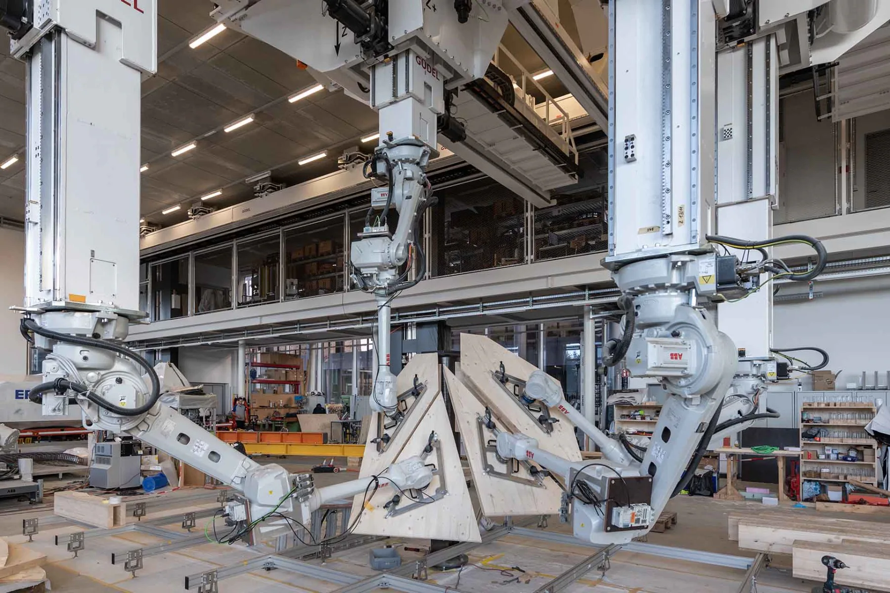 Roboter übernehmen das Heben und Positionieren der schweren Platten.