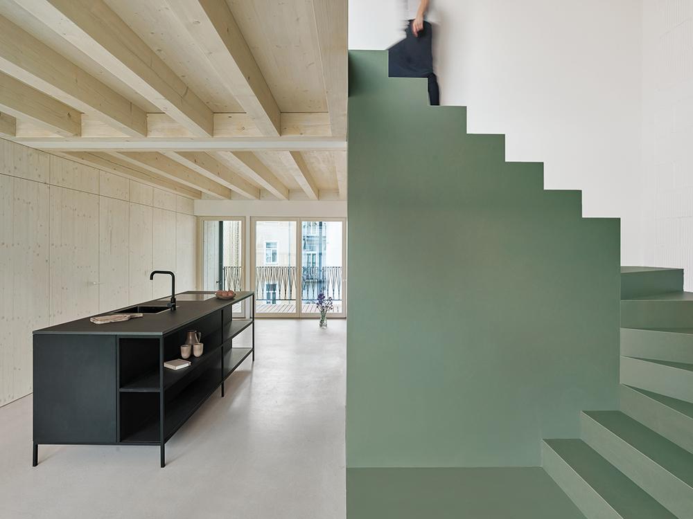 Weiß gestrichene Stampflehmwände aus dem Bodenaushub tragen den First. Die alten Holzdecken wurden durch Aufbeton ertüchtigt.