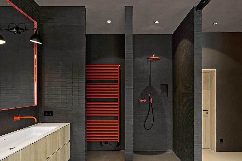 A sliding partition wall consisting of steel and glass creates a visual connection between the bathroom and the bedroom.