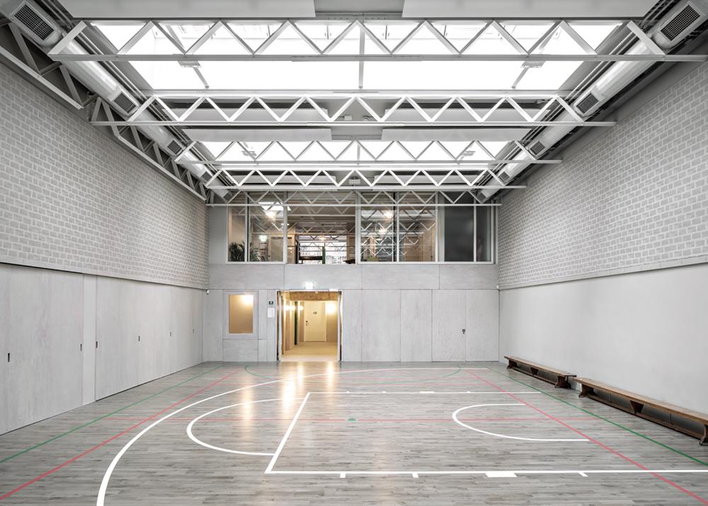 Die Sichtbeziehungen lassen das kleine Gemeindezentrum größer wirken. So fällt der Blick vom hintersten Winkel der Turnhalle über die Lobby hinweg bis hinaus ins Freie.