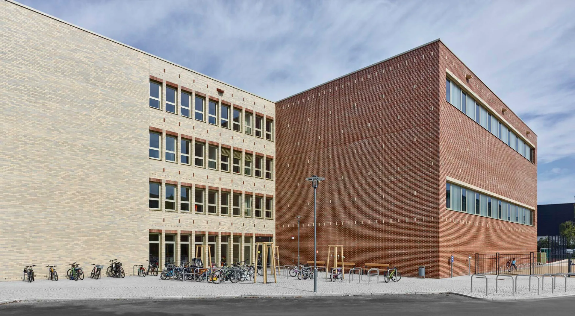 Im größeren Trakt befindet sich die Schule mit Hort, der kleinere beinhaltet zwei gestapelte Sporthallen.