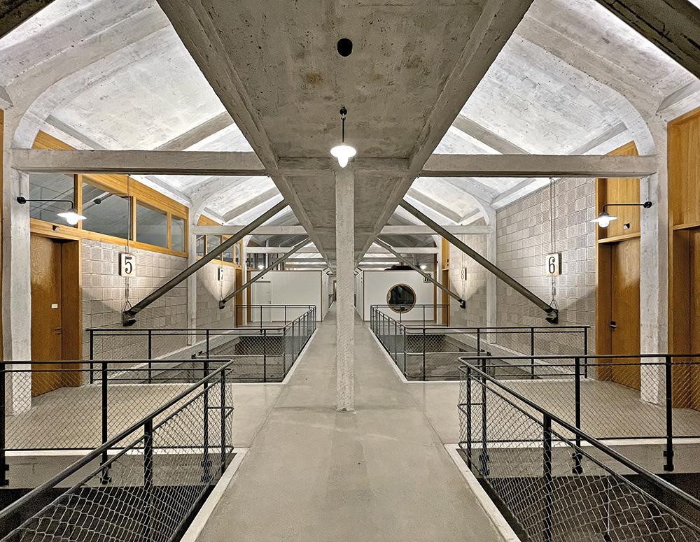 Betonstege führen im zweiten Obergeschoss zu den Ateliers und Doppelzimmern. Ein zweiter Steg eine Etage höher dient nur zu Wartungszwecken. Dort war früher ein Förderband verlegt, von dem aus das Lagergut in die Silokammern gelangte.