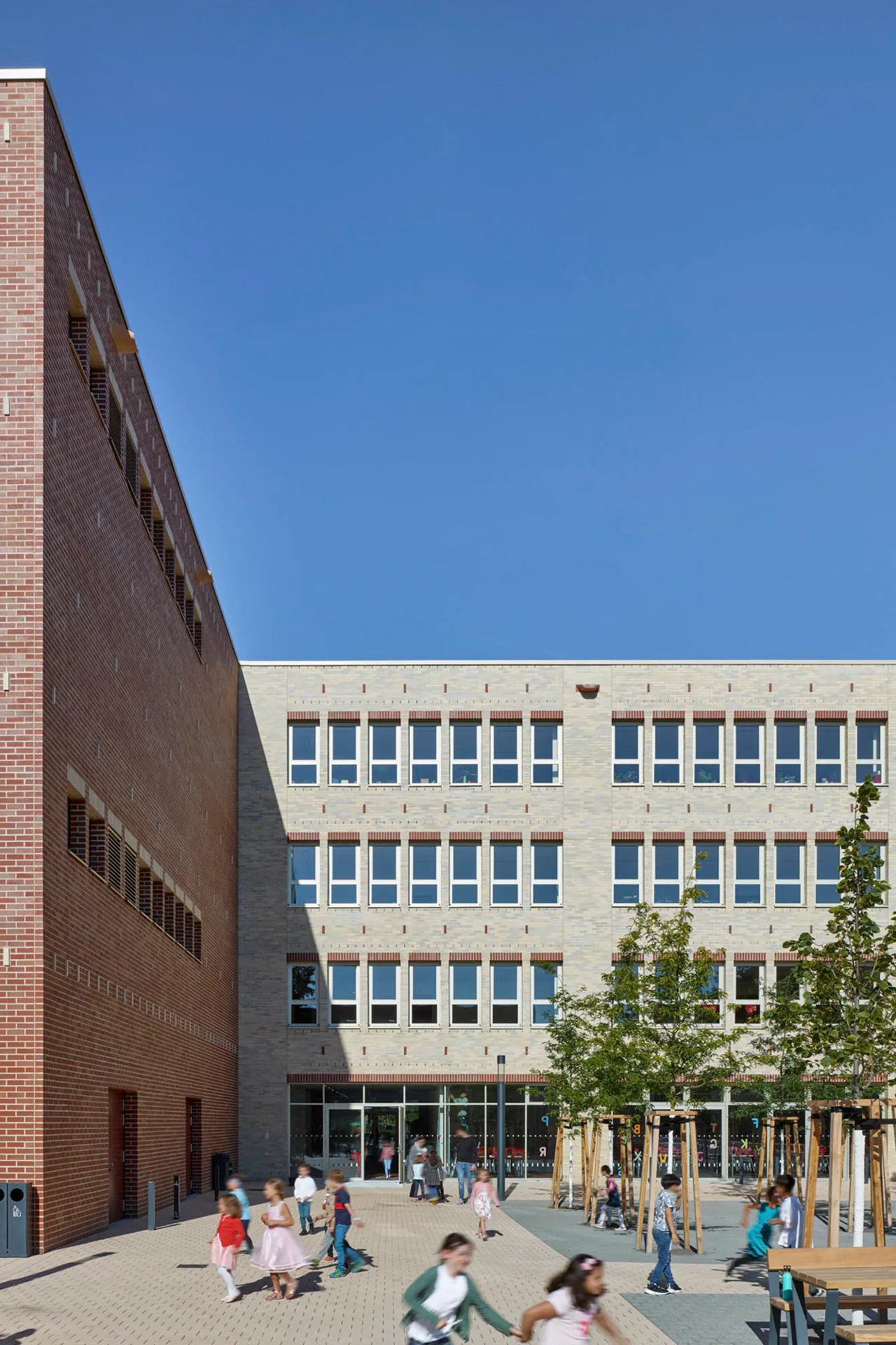 Die Lochfassaden der Grundschule sind in gelbgrauem Klinker gemauert.