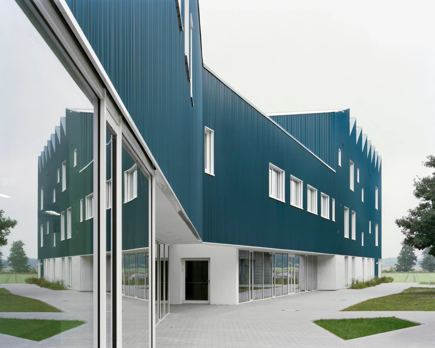 Das Gebäude besteht aus zwei je dreigeschossigen Kopfbauten.