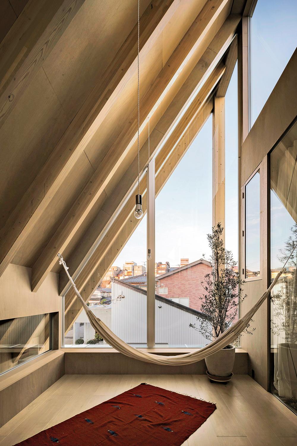 Unter der großen, blechgedeckten Dachscheibe ist die tragende hölzerne Konstruktion sichtbar. Auch Verkleidungen, Böden und Einbaumöbel sind in Holz ausgeführt.