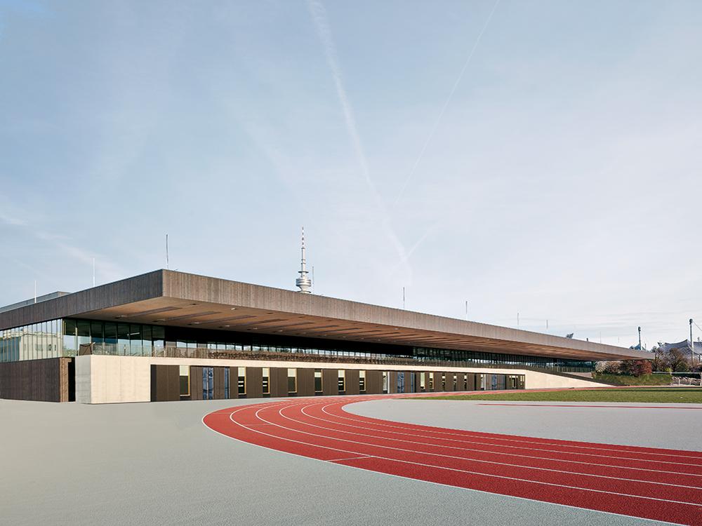 Das Holzdach kragt 19 m weit bis über die Tartanbahn aus. So können die Sportler witterungsgeschützt in den angrenzenden Diagnoseräumen untersucht werden.