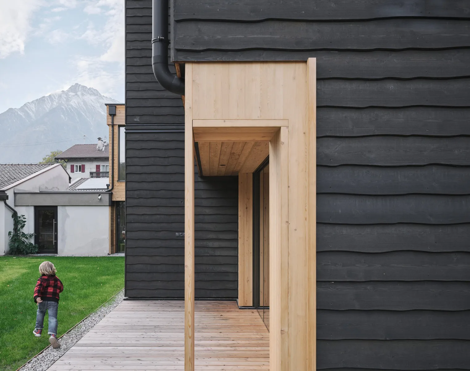 Die dunkle, vorgehängte Holzschalung der Fassade ist mit einem mit Farbpigmenten versetzten, schadstofffreien Leinöl gestrichen.