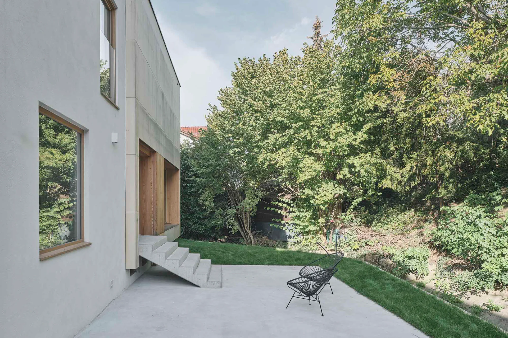 Eine nackte, geländerlose Betontreppe führt in den Garten.