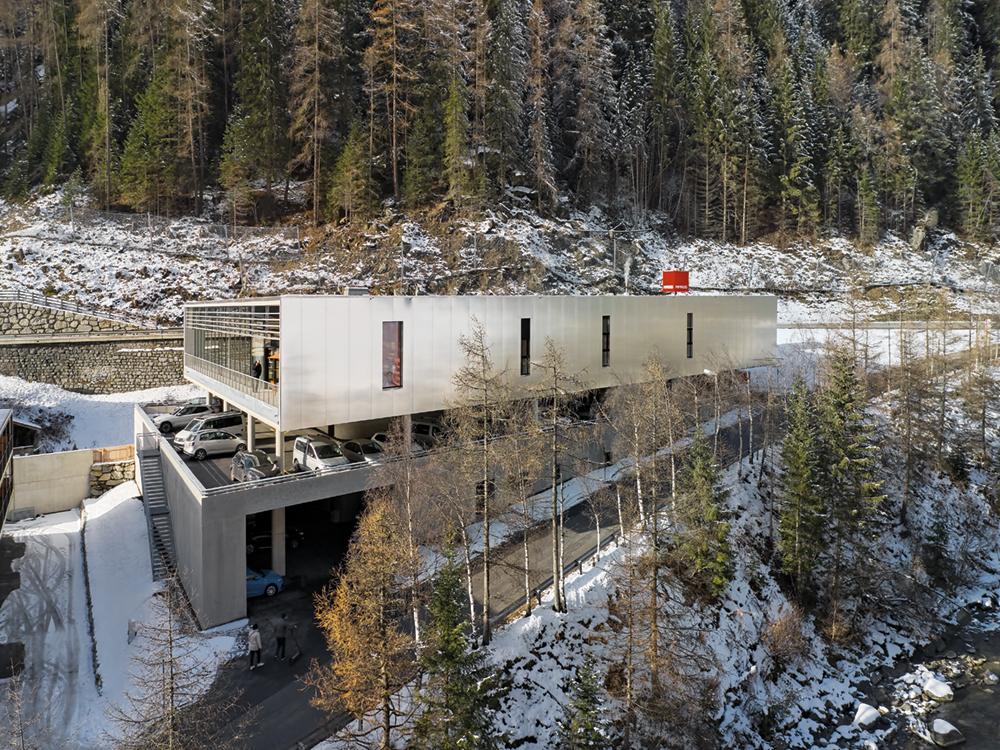 Car-friendly and yet space-saving – this compromise defined the cubage of the supermarket sited on a sloping hill. Delivery, parking deck and sales floor are stacked along three different levels.