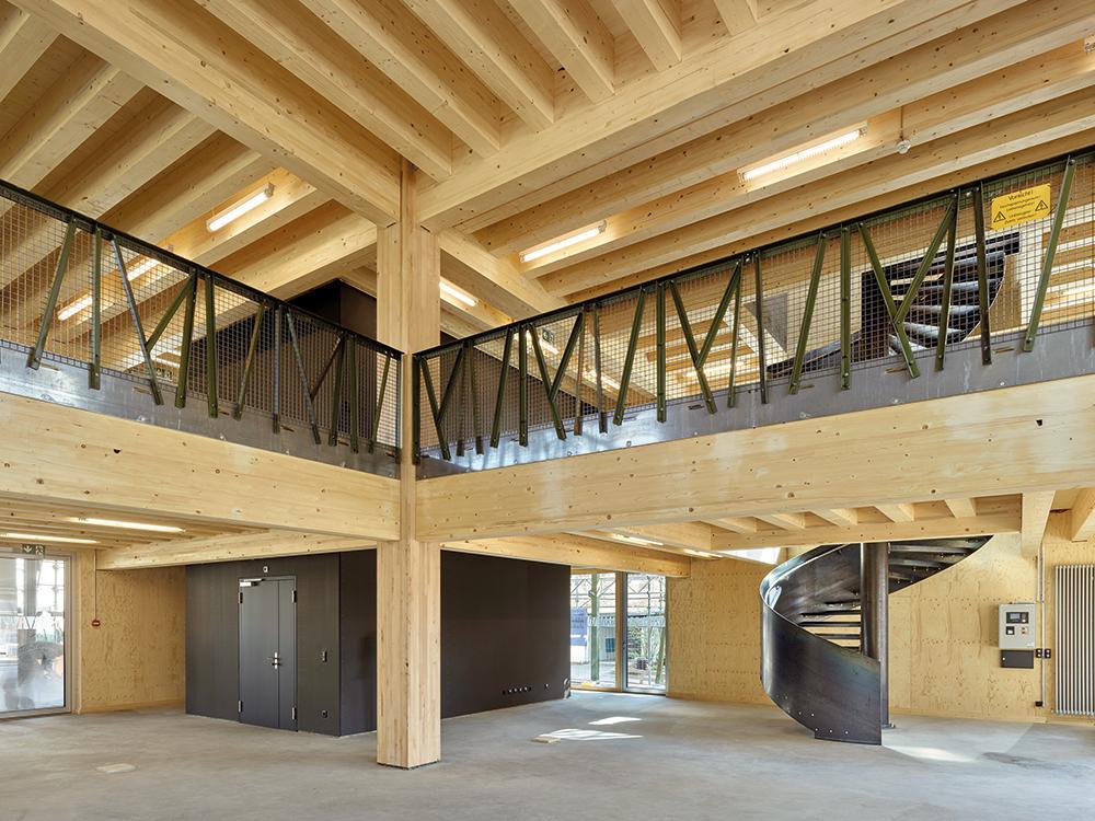 Das hölzerne Innenleben des Gebäudes steht in markantem Kontrast zum äußeren Rankgerüst, das die Architekten mit einem Faraday-Käfig vergleichen. Es wurde aus alten Strommasten hergestellt.