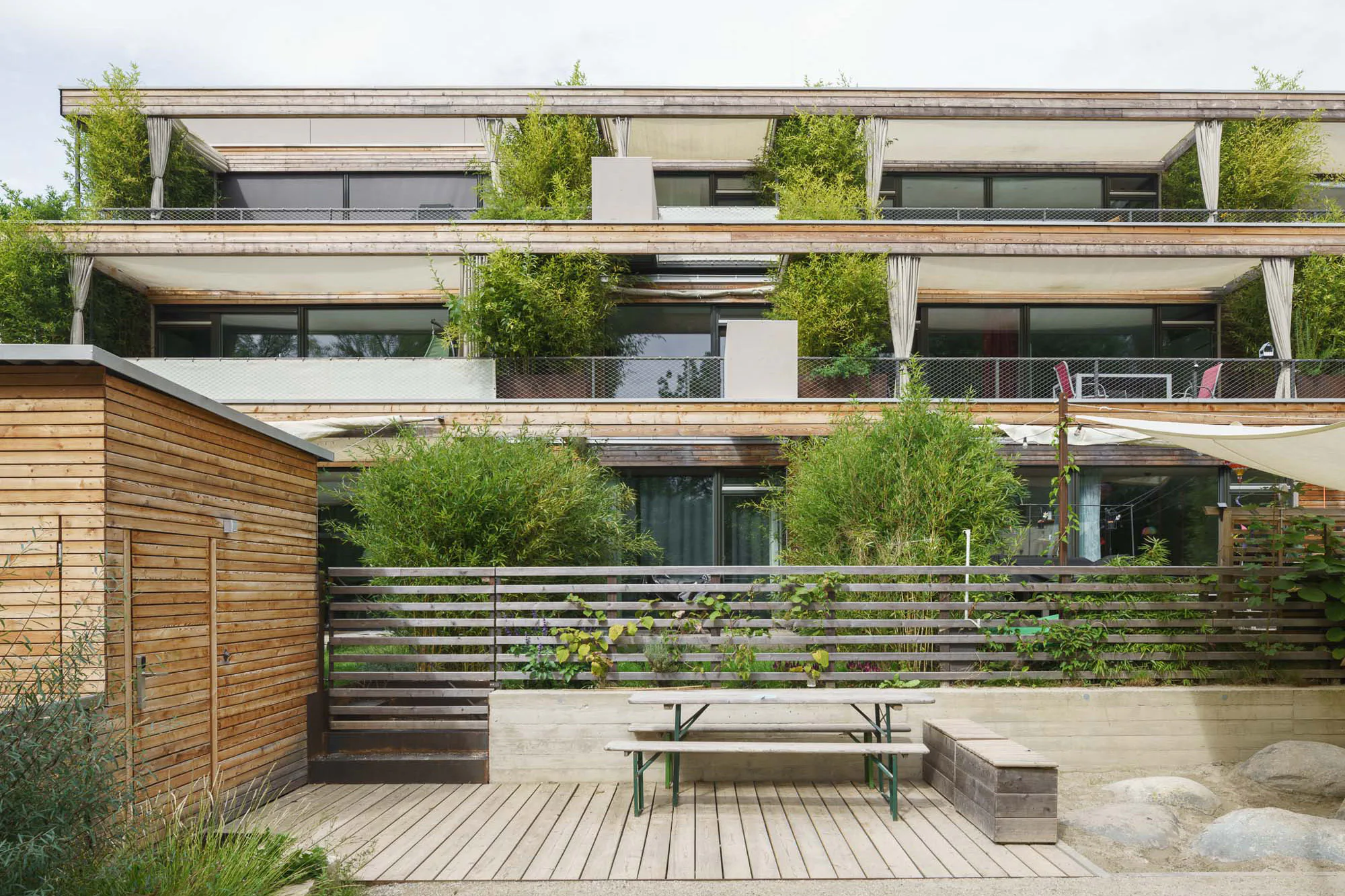 Eine horizontale Lärchenholzschalung und viel Grün bestimmen das Erscheinungsbild der Wohnanlage StadtNatur.