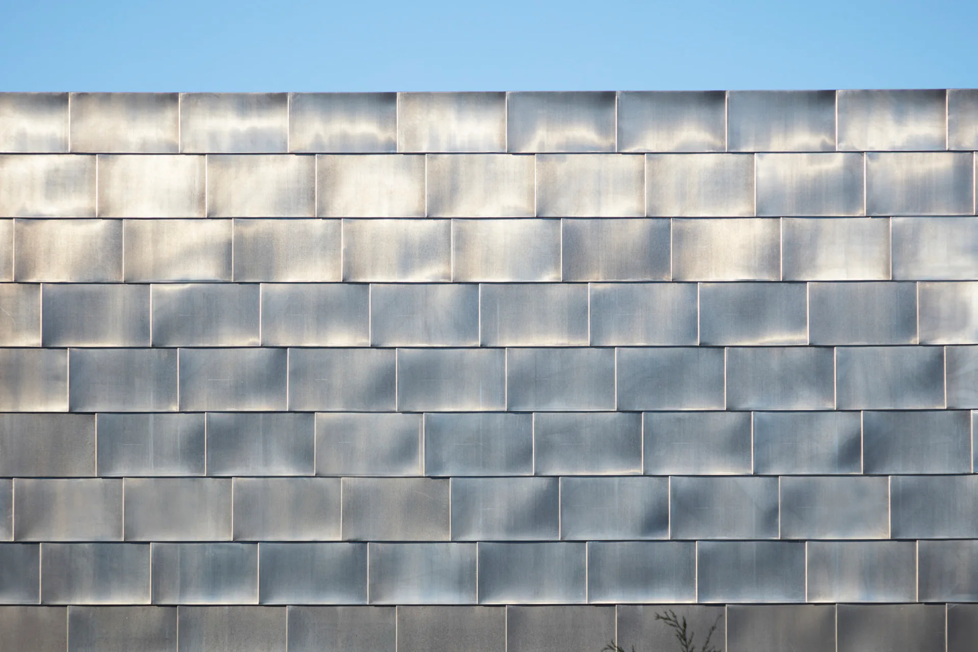 Der Neubau weist eine schiffsförmige, zinkverkleidete Fassade auf.