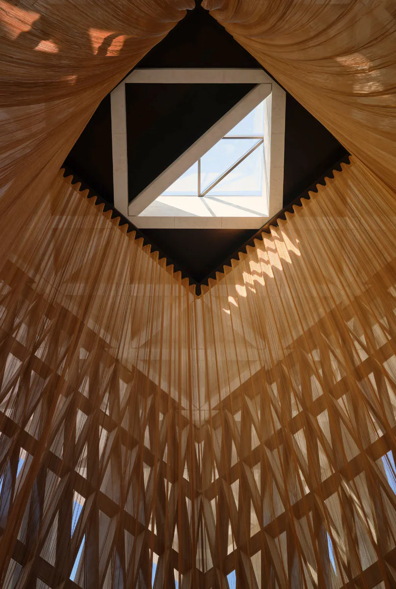 Vom zentralen Oberlicht der Synagoge hängt ein Netz aus Bronze herab.