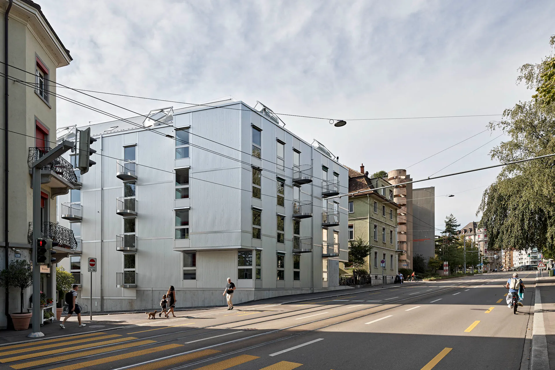 Das Mehrfamilienhaus besitzt eine silbern schimmernde Fassade.
