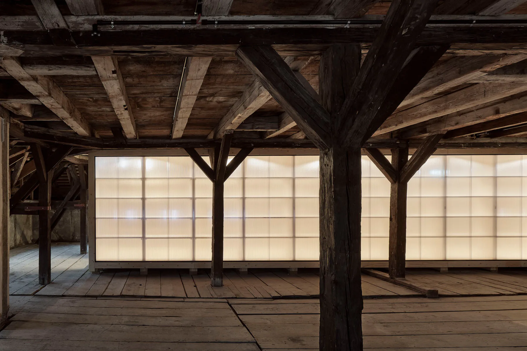 In dem großen Raum steht eine freistehende Lagerbox aus Holz, die mit Polycarbonat-Stegplatten umhüllt ist.