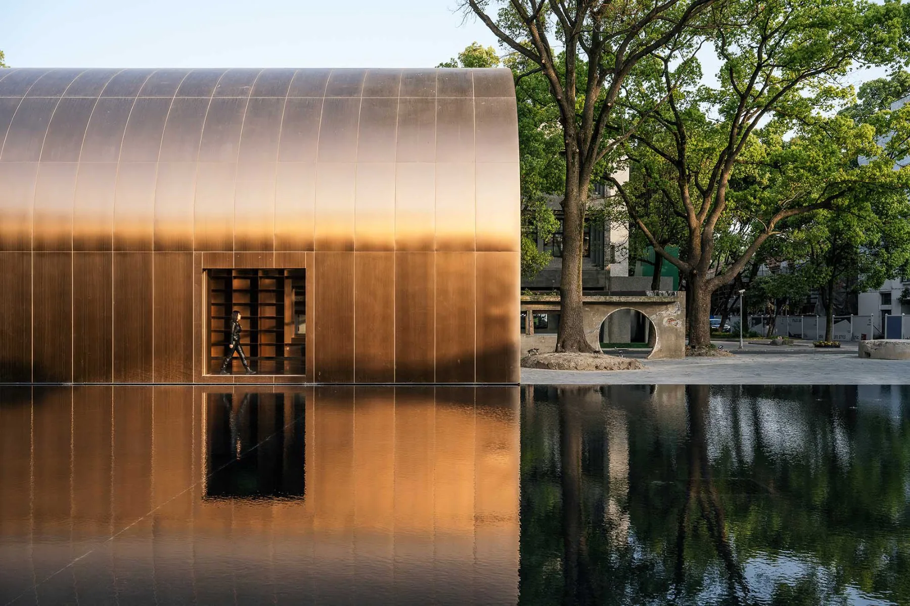 Unter dem kupferverkleideten Tonnendach in einem Shanghaier Gewerbepark öffnet sich ein Raum für Ausstellungen und Veranstaltungen.