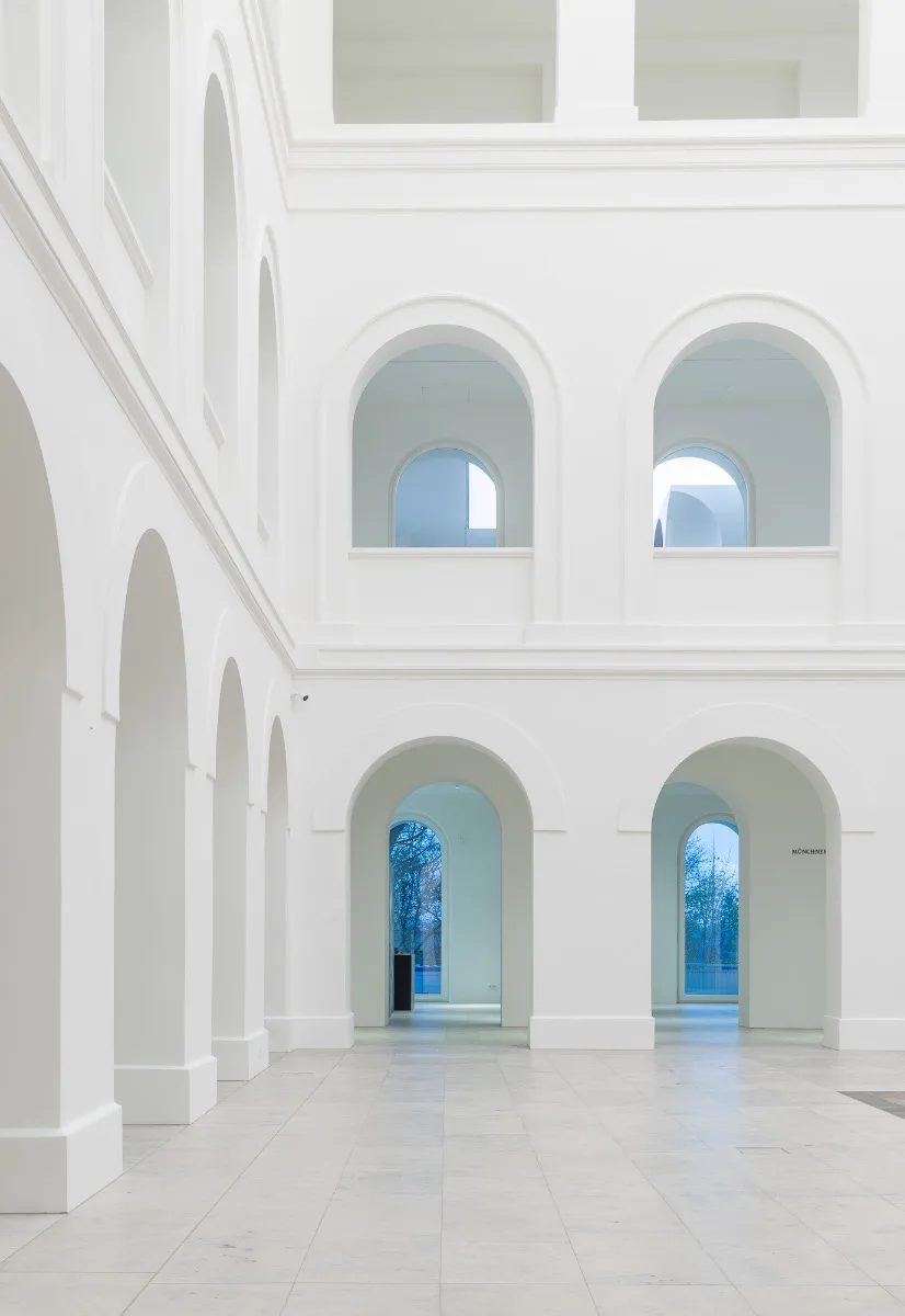 Weiße Arkadengänge schaffen gerahmte Blicke zu den Ausstellungsräumen und ins Freie.