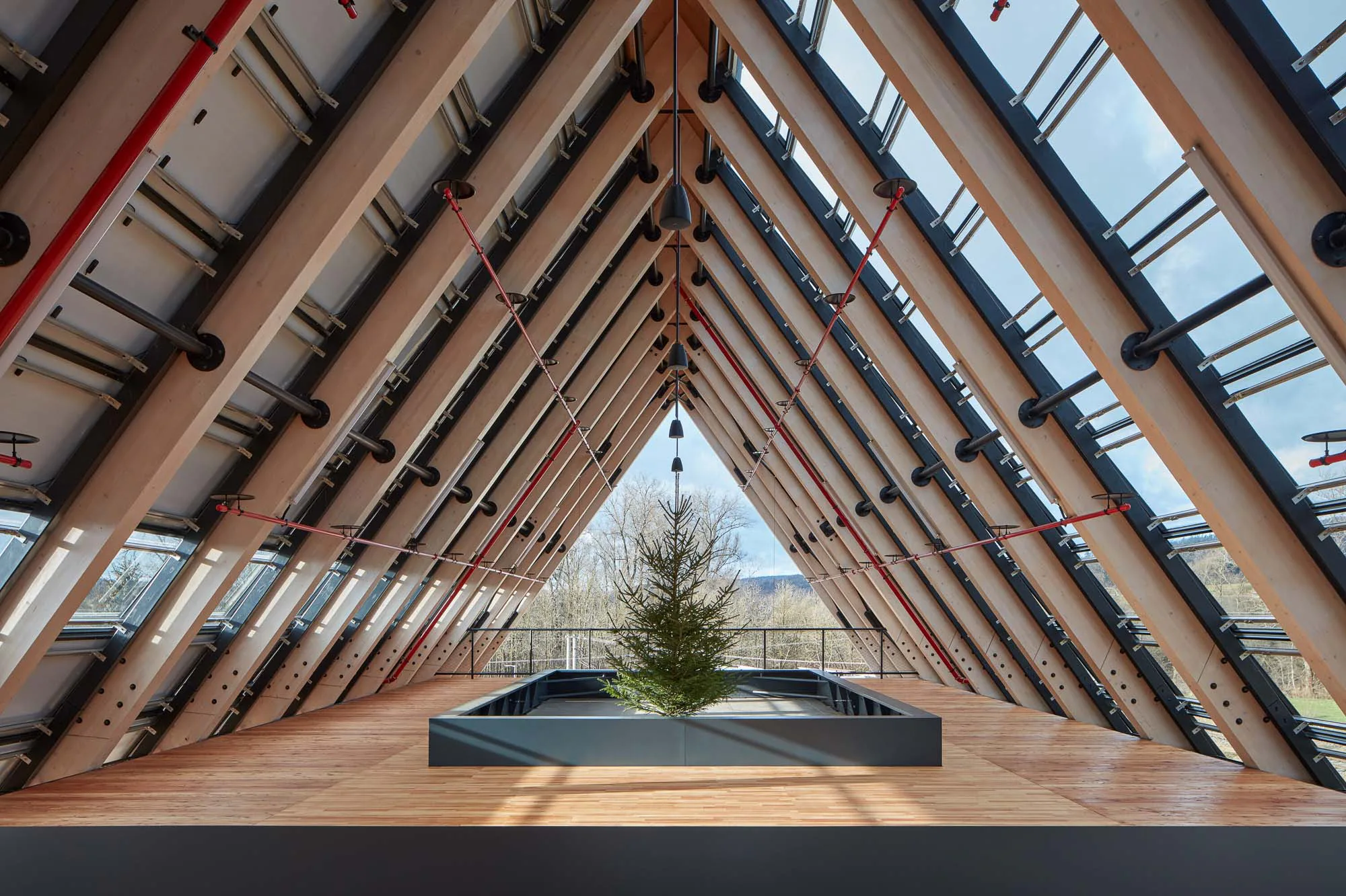 Das traditionelle Satteldach aus Holz und Glas verleiht dem Gebäude eine skulpturale Erscheinung.