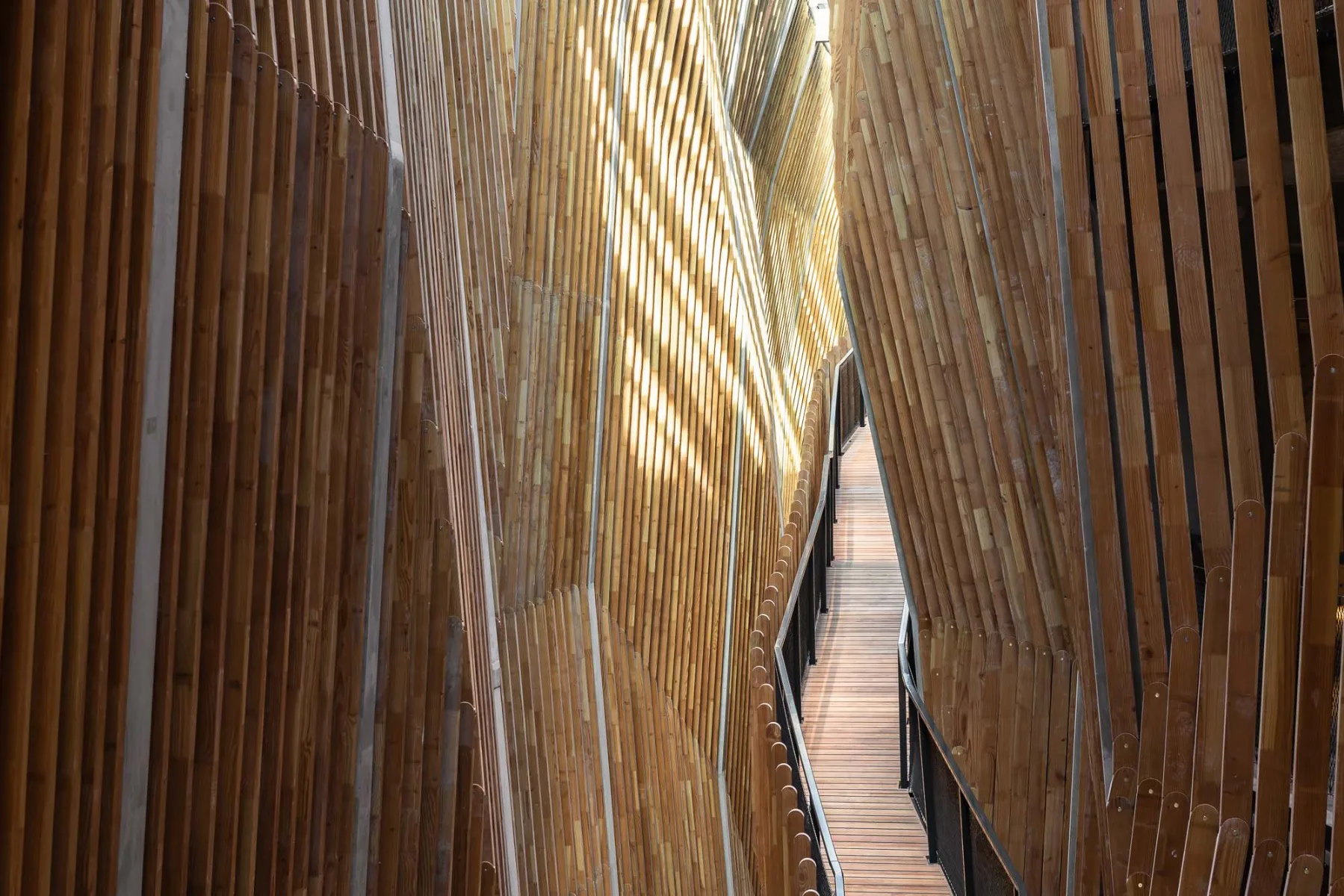 Das gebäudehohe Atrium ist umgeben von umlaufenden Holzlamellen.