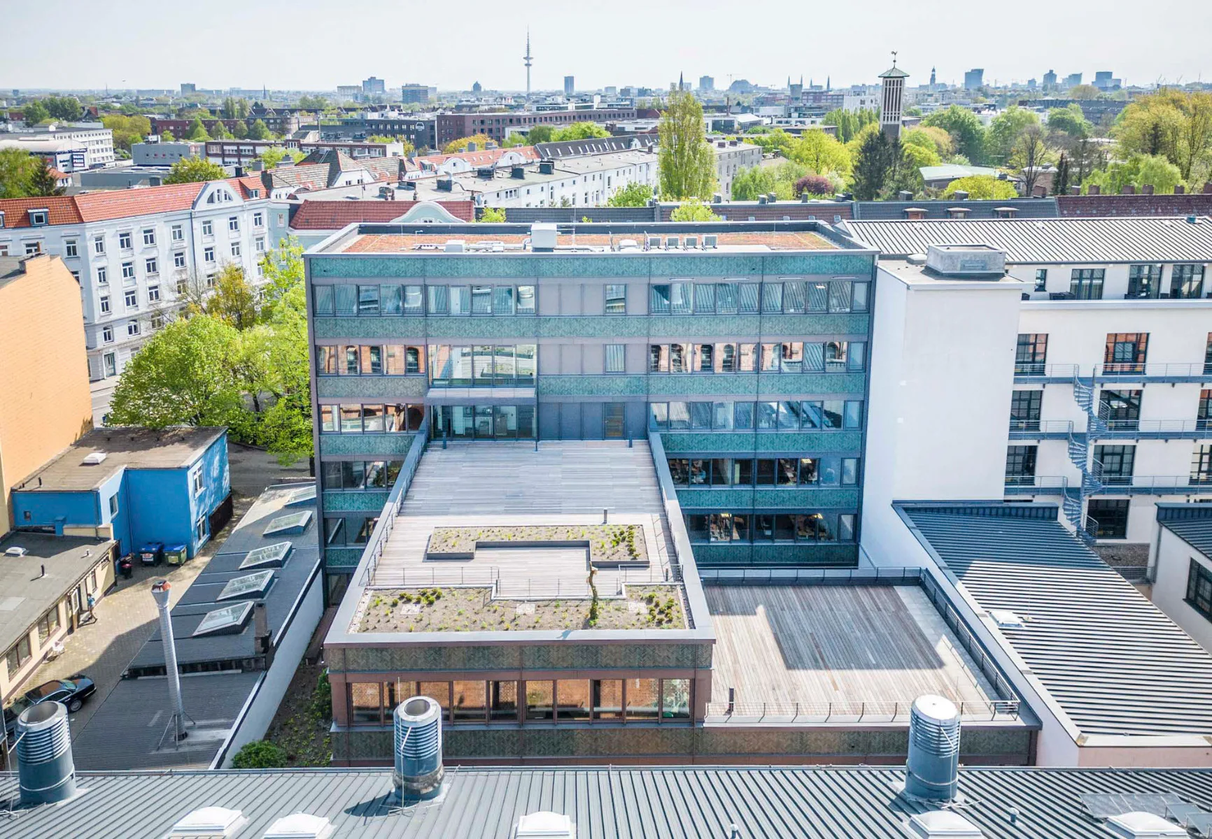 Die grüne Keramikfassade greift den kleinteiligen Charakter der umgebenden Backsteinfassaden auf.