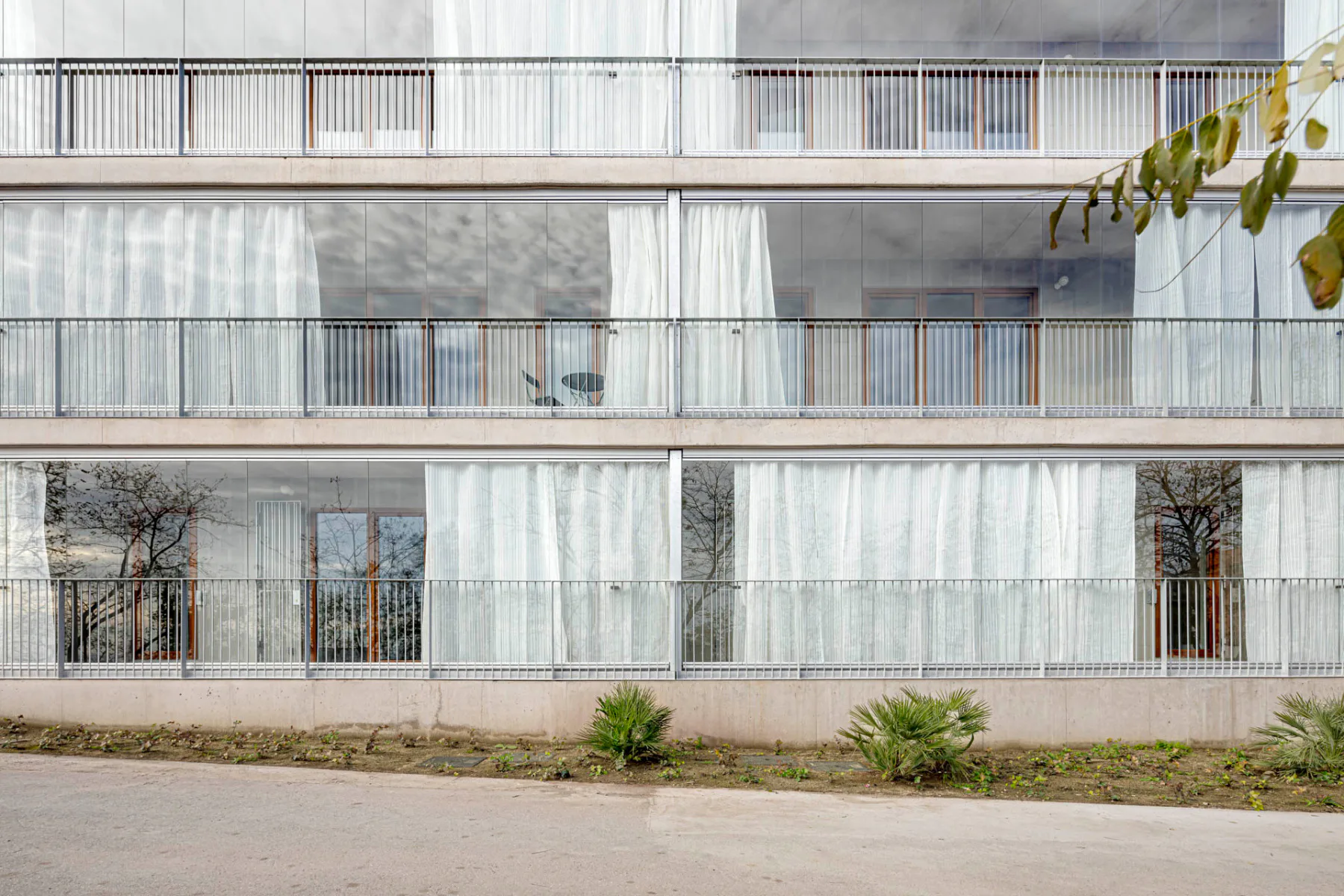Ansicht der Fassade mit gläsernen Schiebeelementen und Vorhängen