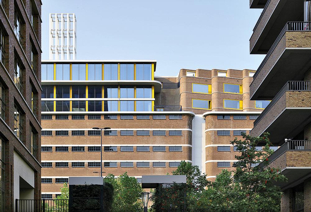 Der neue Wohnaufbau ist an der ZickzackFassade erkennbar. Daneben befindet sich ein Teil des Altbaus, der eine neue Glasfassade erhielt und als Büro genutzt wird.