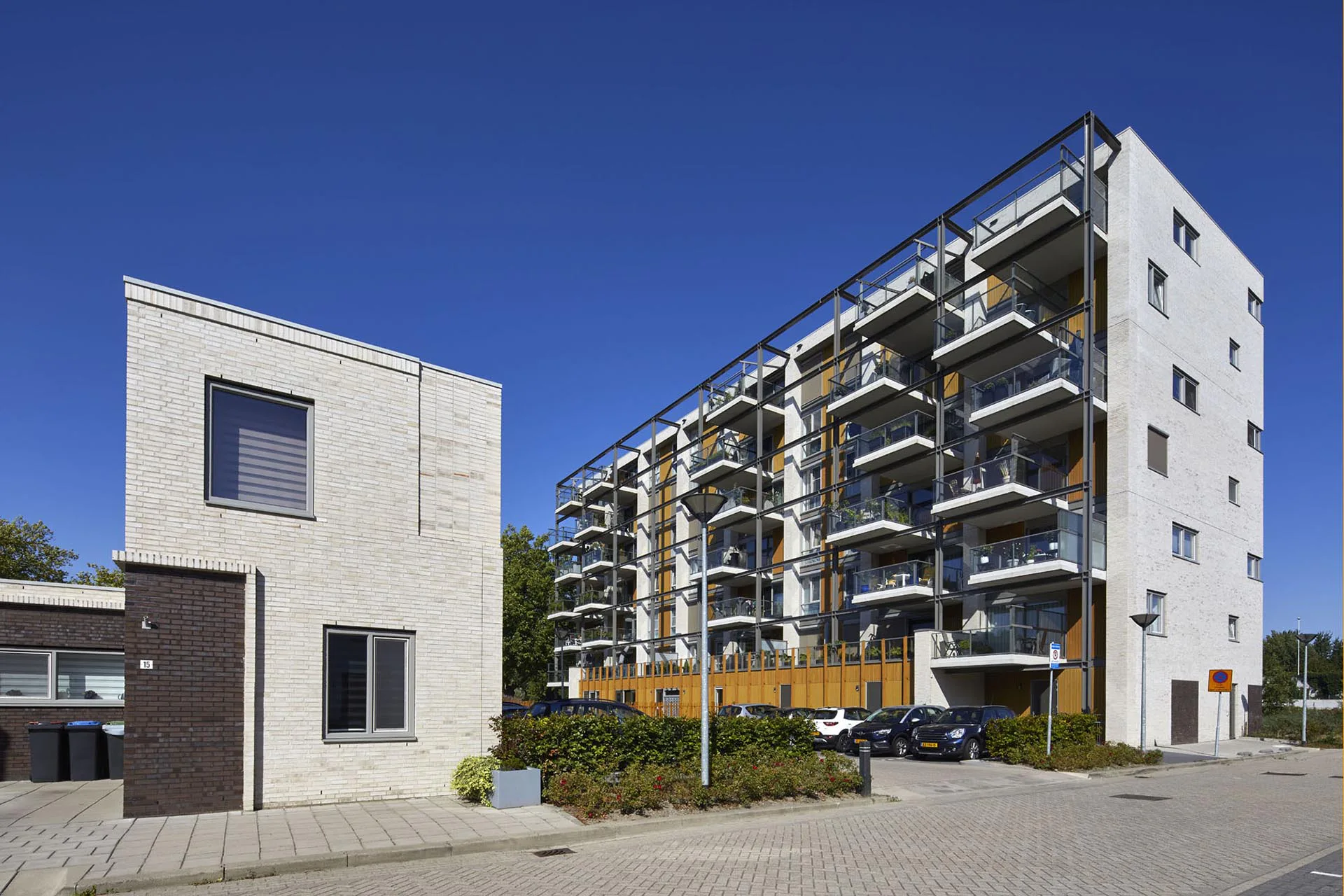 Ein beige-weißer Klinker sowie Holz sorgen für ein helles Fassadenbild, das das Konzept des Baus unterstreicht.