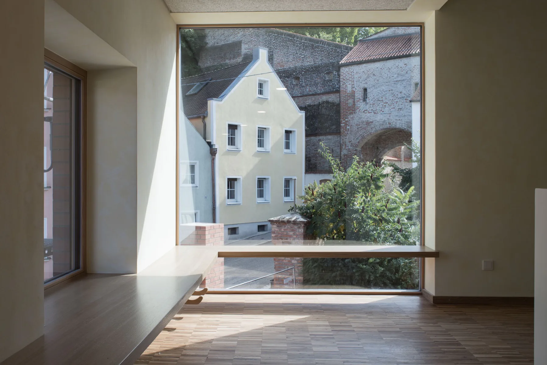 Die Fassade ist an drei Seiten mit Klinker geschlossen, die vierte Seite öffnet sich vollkommen verglast zum Garten und zur Stadtmauer hin.